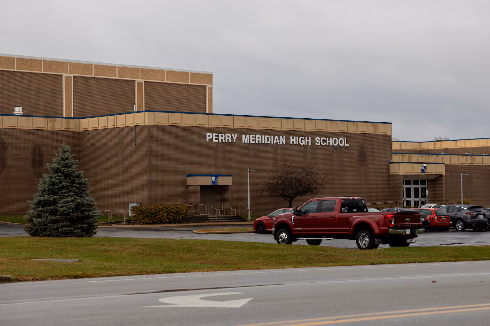 A large brick school building has a sign reading Perry Meridian High School across the front.