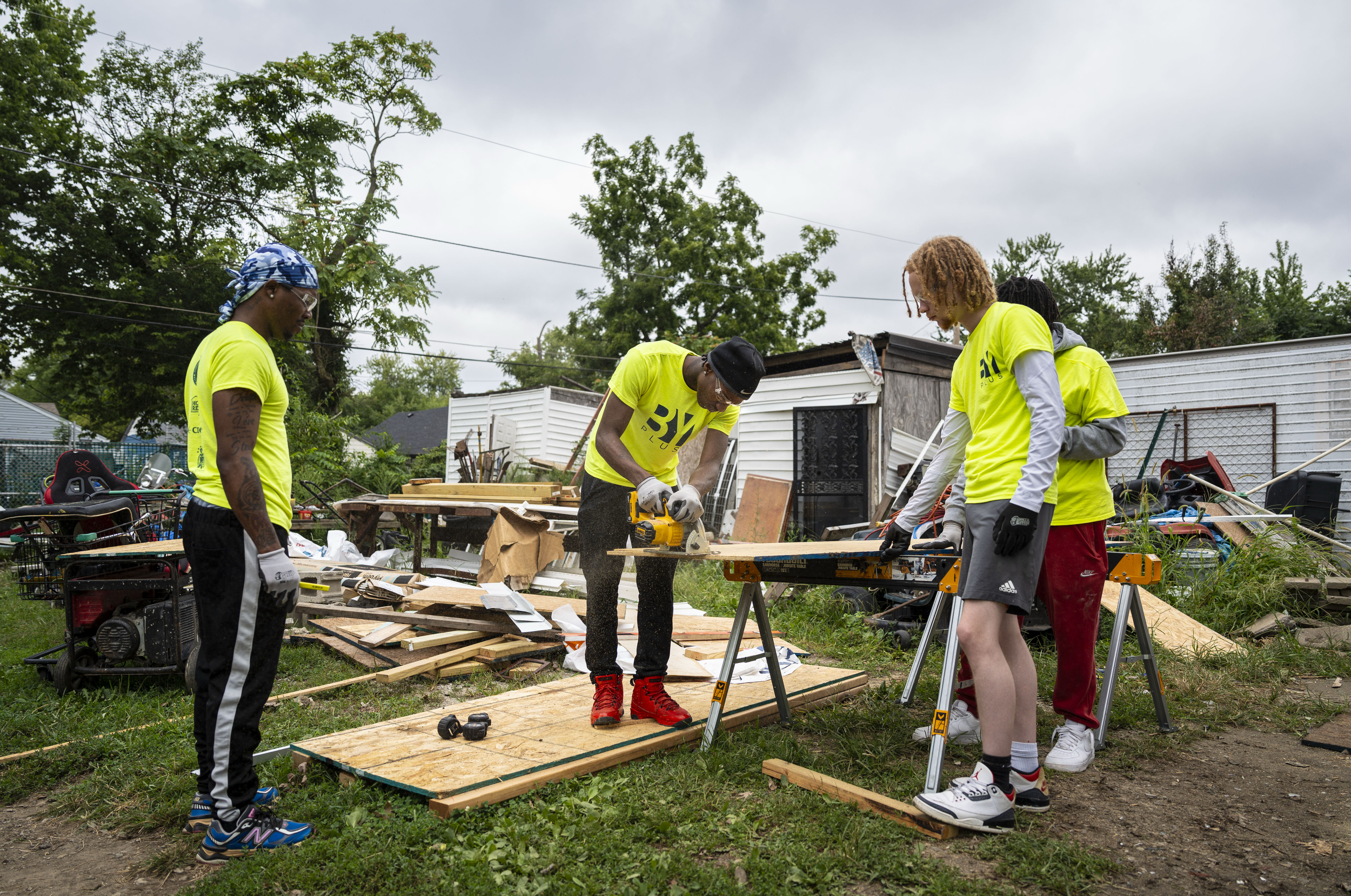Students with the Indiana Construction Roundtable Foundation watch as Tylan Hubbard (second from left) cuts plywood to fit beneath an overhang during a work experience program with Home Repairs for Good on Aug. 21, 2025, in Indianapolis.